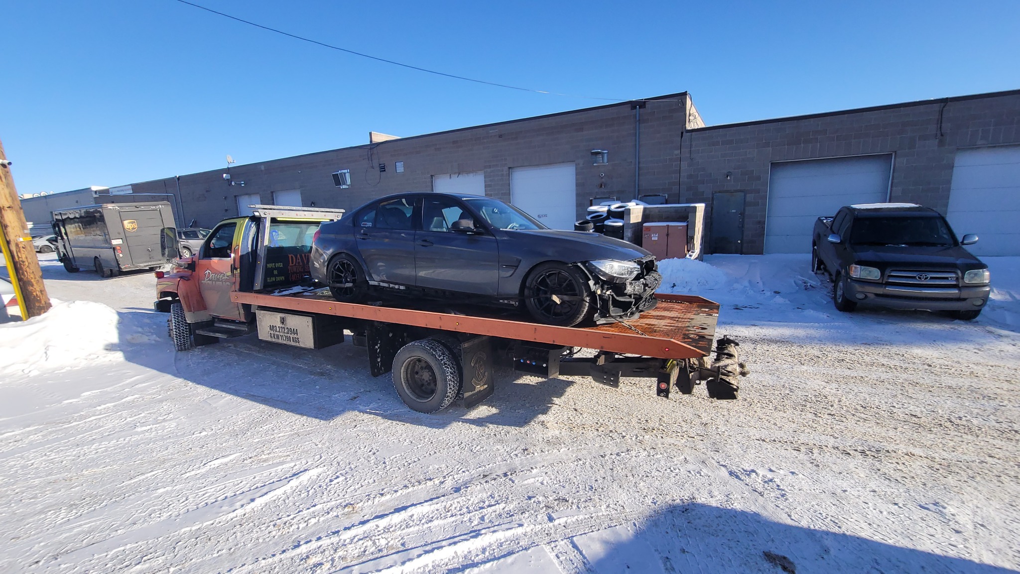 Emergency flatbed towing of a damaged car in Calgary winter
